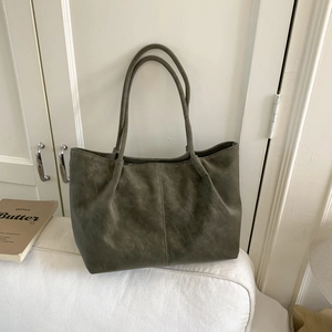 Detail of olive green faux suede tote bag with long double straps and pleated top
