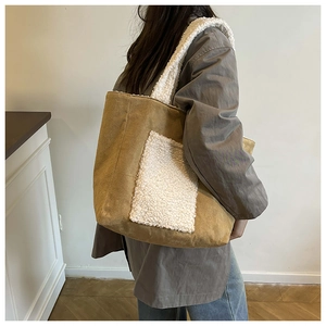 Brown suede tote bag with white fleece pocket shown on a model for autumn winter style