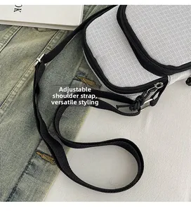 Close-up of contrast crossbody bag with mesh texture and adjustable black shoulder strap