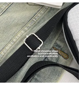 Detailed close-up of adjustable silver metal buckle on a black fabric shoulder strap