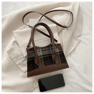 Détail du sac à main en tweed à carreaux marron de style britannique avec finitions en cuir