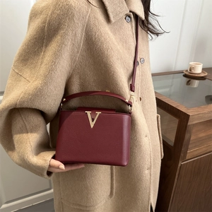 Elegante borsa a tracolla bordeaux con dettaglio a V e cappotto invernale color beige