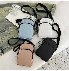 Flat lay of mini nylon crossbody bags in four colors with adjustable shoulder straps