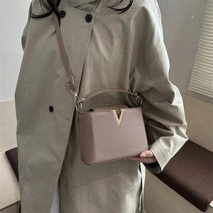 Borsa a mano minimalista in pelle beige con fibbia a V dorata e tracolla regolabile