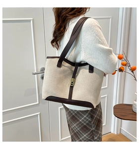 Model showing oversized canvas tote bag in beige with dark brown leather straps