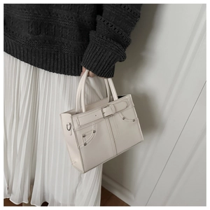 Détail du sac à main en cuir PU blanc crème avec rivets et boucle décorative