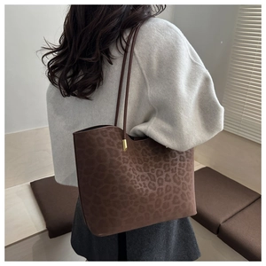 Detail view of large leopard print tote bag in dark brown suede with thin straps