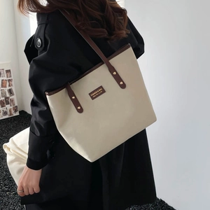 Grand sac cabas crème minimaliste avec poignées marron foncé et écusson élégant