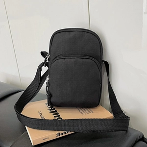 Compact black canvas crossbody bag with dual zipper pockets and wide woven strap
