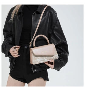 Détail du sac beige avec imprimé géométrique et inscription Fashion & Bags en métal