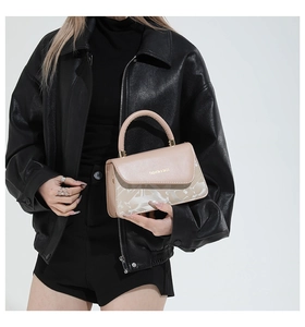 Détail d'un sac à main beige élégant avec texte fashion et texture marbrée légère