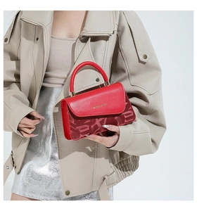 Détail du sac rouge avec lettrage doré et panneau inférieur à texture géométrique