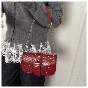 Detail der roten Lackleder-Schultertasche mit Silbernieten und Metallkettenriemen