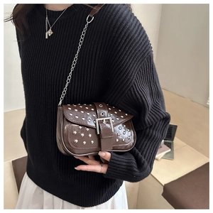 Nahaufnahme der braunen Vintage-Ledertasche mit silbernen Nieten und einer Metallkette