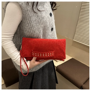 Détail d'un sac à main rouge à motif léopard avec des clous dorés décoratifs sur l'anse