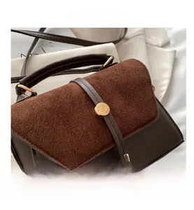Détails du rabat en daim et de la boucle dorée d'un sac à bandoulière marron rétro