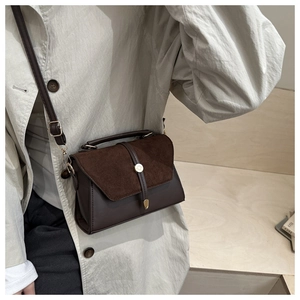 Détail du sac bandoulière en daim patchwork avec fermoir doré et texture en cuir