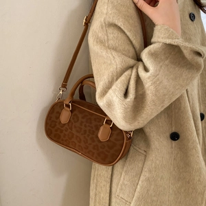 Detail of leopard print faux fur handbag with leather handles and gold-tone hardware