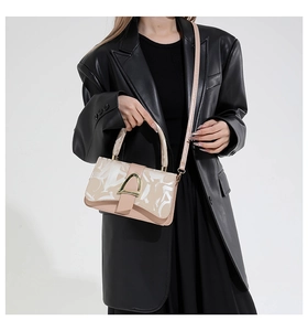 Detail of trendy crossbody bag with gold D-ring buckle and abstract print pattern