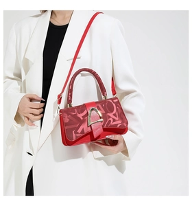 Fashionable red square handbag with gold U-buckle shown on professional model