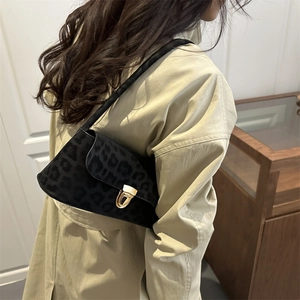 Sac à bandoulière léopard vintage avec boucle en métal doré et tissu texturé sombre chic