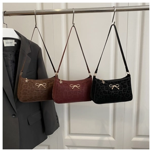 Detailed view of leopard print baguette bags with gold bow and flower zipper pulls