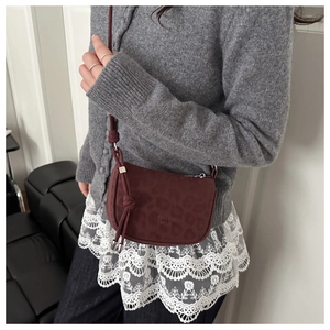 Détail d'un sac à bandoulière bordeaux imprimé léopard avec bandoulière à nœuds chic