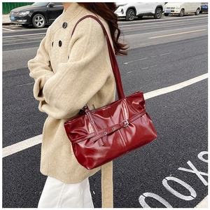 Vue de rue du sac cabas rouge foncé en similicuir verni avec boucle argentée et coutures