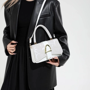 Chic white square crossbody bag with abstract prints and golden hardware on model
