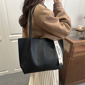 Large black minimalist tote bag with decorative fashion ribbon on long shoulder straps