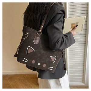 Detail view of large brown faux suede tote bag with cute cat face illustration