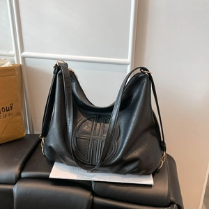 Retro black leather tote bag with large capacity and circular embossed logo design