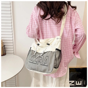 Detail of white canvas crossbody bag with grey mesh pocket and large KERA lettering