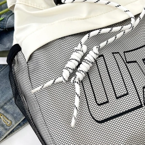 Macro detail of high-capacity sport bag showing black mesh overlay and braided drawstring