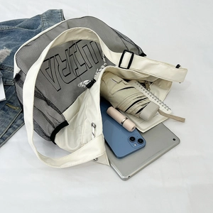 Top view of white canvas and black mesh bag showing spacious interior with daily items
