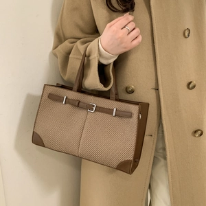 Retro houndstooth tote bag with brown leather trim and metal buckles shown by model