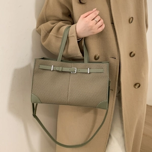 Morandi green crossbody bag in herringbone fabric with leather trim on camel coat