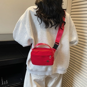 Minimalist red nylon crossbody bag for daily leisure featuring adjustable shoulder straps