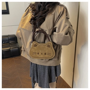 Sac à main chat marron porté en bandoulière avec poignée supérieure sur un mannequin