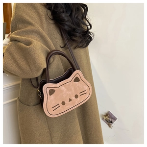 Gros plan d'un sac bandoulière mignon en forme de chat sur un mannequin en manteau