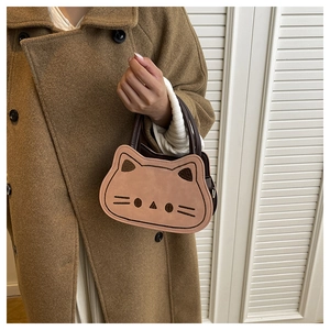 Détail d'un mini sac à main rose en forme de chat avec oreilles et poignée marron