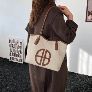 Elegante borsa tote in tessuto beige con finiture in pelle marrone e logo sulla spalla