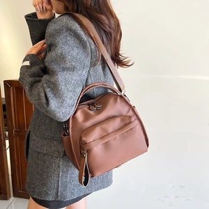 Brown nylon multi-layer crossbody bag with large capacity shown on a model