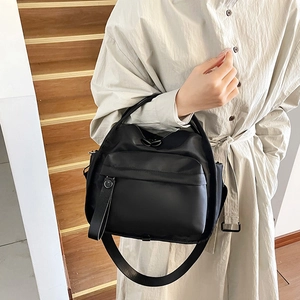 Modern black nylon multi-layer crossbody bag with wide strap on wooden stairs