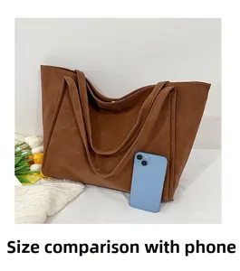 Detailed comparison of the large brown faux leather tote bag size with a mobile phone