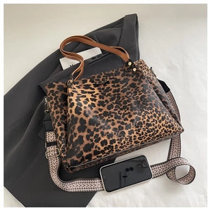Detail view of large leopard print tote bag with removable woven shoulder strap and PU leather