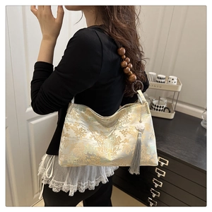 Detail of floral jacquard fabric and wooden bead shoulder strap on a retro bag