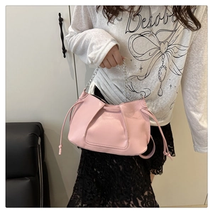 Detail of pink shoulder bag with metal chain handle and side drawstring tassels