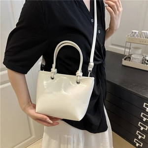 Chic white mini tote bag with cylindrical handles and adjustable crossbody strap