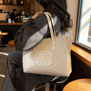 Classic cream-colored monogram tote bag with embossed M-logo for casual fashion style